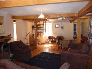 Large lounge with wood burning fire and access to the deck